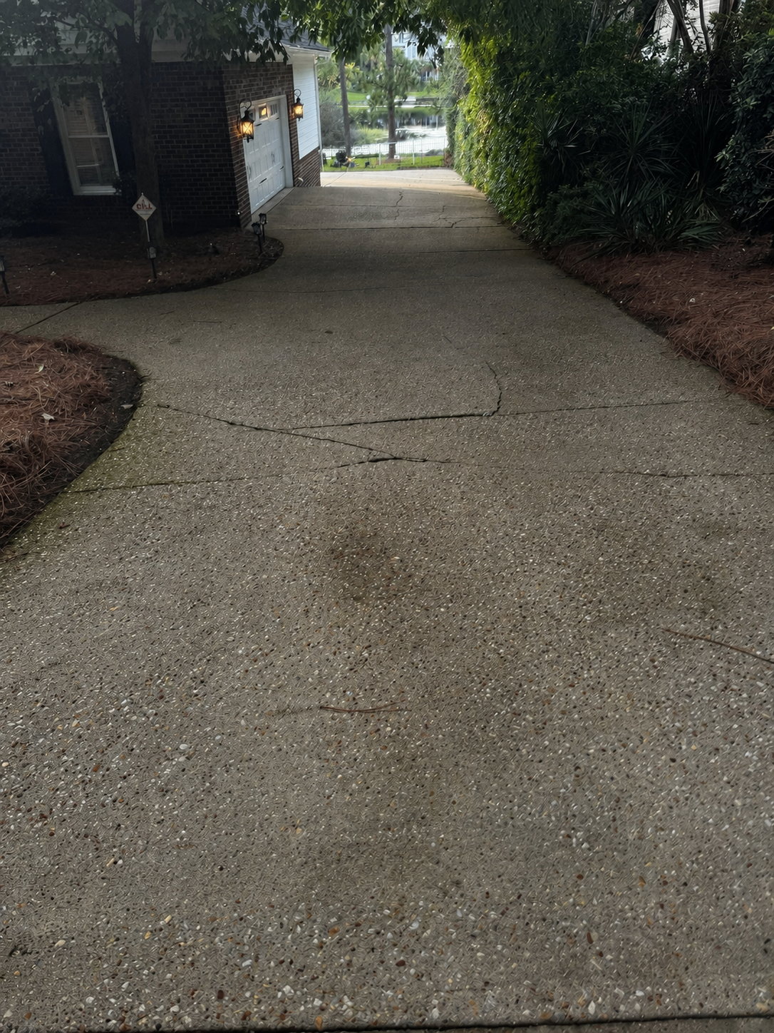 Driveway covered in built-up dirt and grime before pressure washing