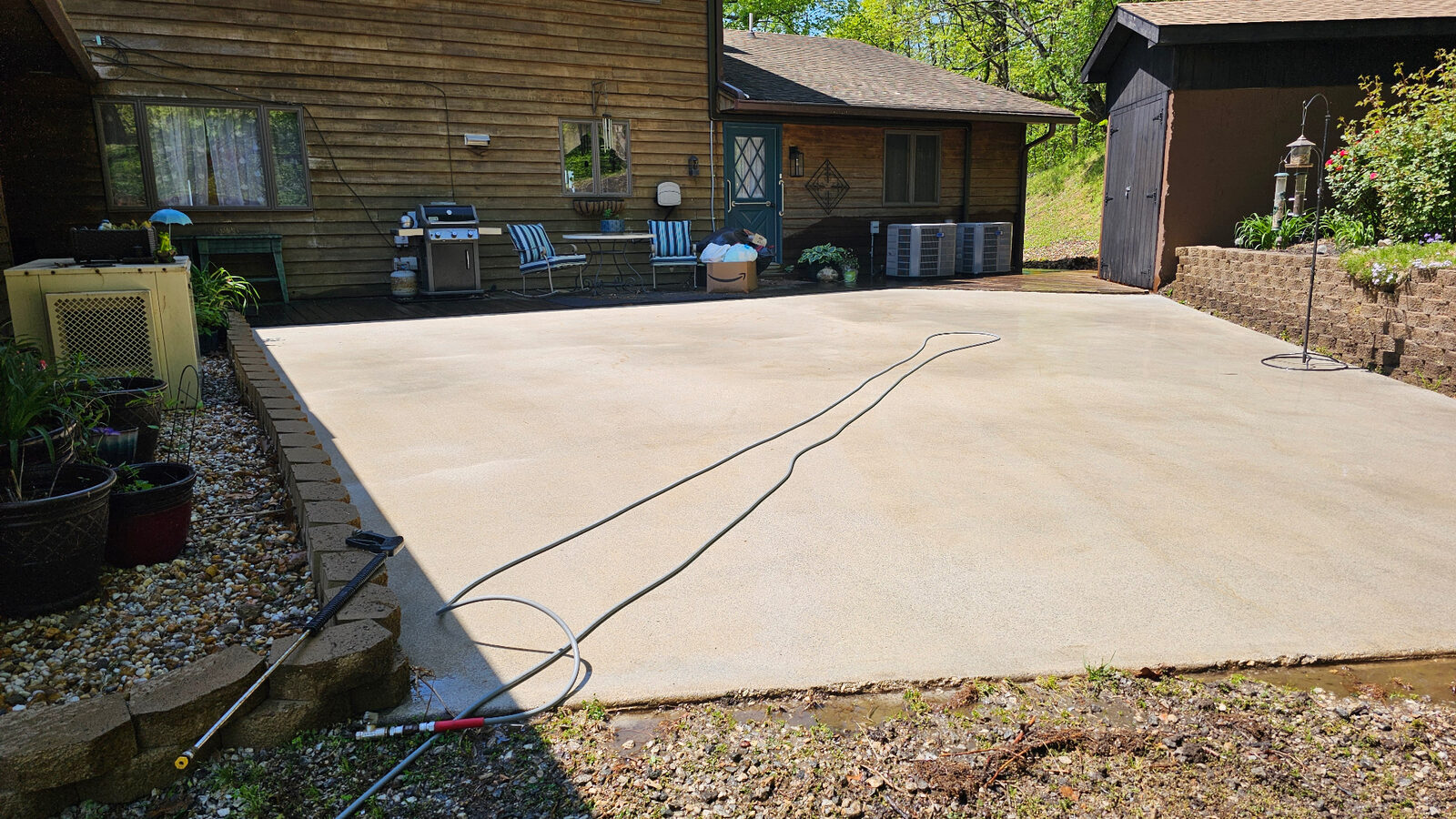 The same concrete patio after pressure washing, clean and bright